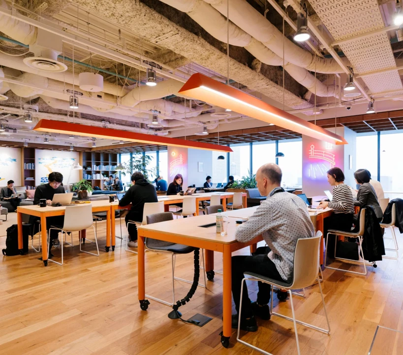 WeWork Japan のクリエイティブなオフィス空間。壁面一面に描かれたダイナミックなアート。